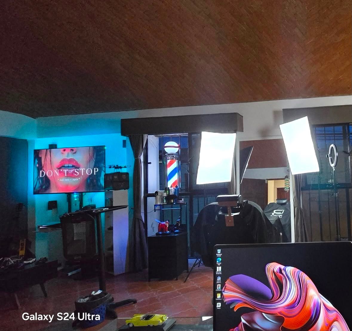 Ambiente general del estudio con pantalla, luces neón azules y decoración urbana