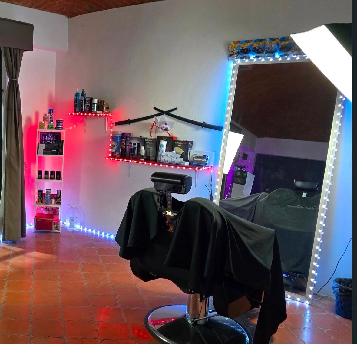 Silla de barbero premium frente a espejo con luces led